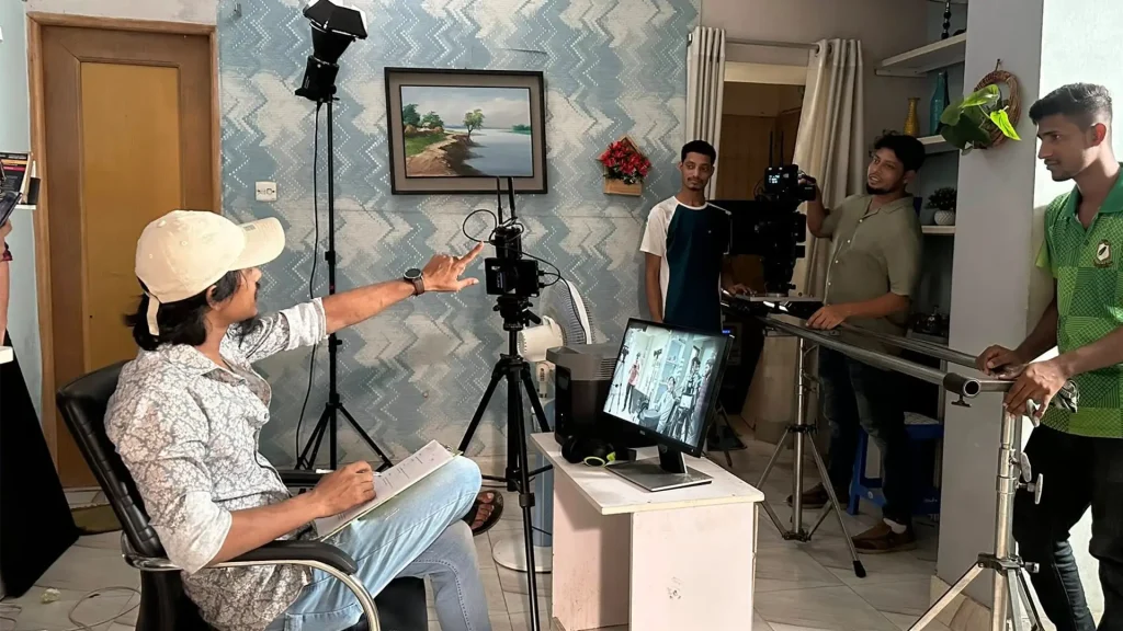 Faisal Khan Shuvo directing a scene beside the production monitor on set